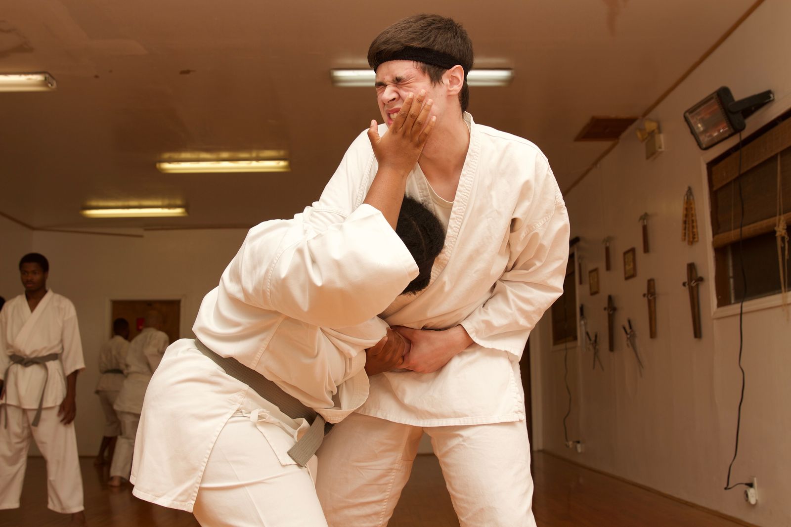 Two students practicing a standing self-defense technique in the dojo